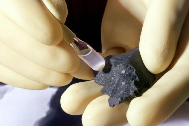 Fragment of the Murchison meteorite (at right) and isolated individual particles (shown in the test tube). (Public Domain)