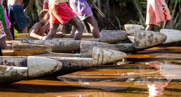 Fragmentos de guerreros en canoa de la tribu Asmat en el río (gudkovandrey Adobe Stock)
