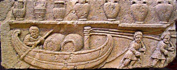 A Gallo-Roman relief depicting a river boat transporting wine barrels, an invention of the Gauls that came into widespread use during the 2nd century. Above, wine is stored in the traditional amphorae, some covered in wicker.
