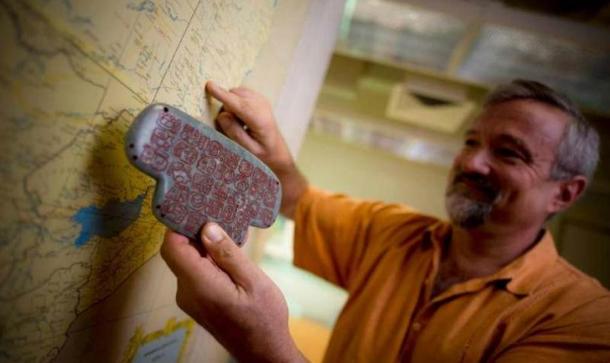 UC San Diego archaeologist Geoffrey Braswell holds a replica of the Maya jade pendant.
