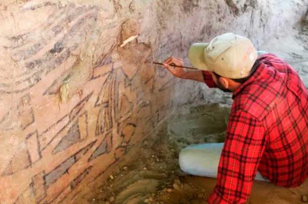 Sâm Ghavami usa un pincel para revelar el mural, apodado la Huaca Pintada peruana. (Sam Ghavami)