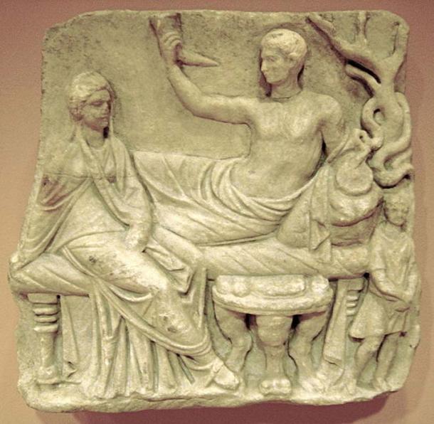 Grave relief showing the deceased and his widow in a funeral feast where they are depicted in a godlike manner. Roman marble work, 1st century AD. (Public Domain)