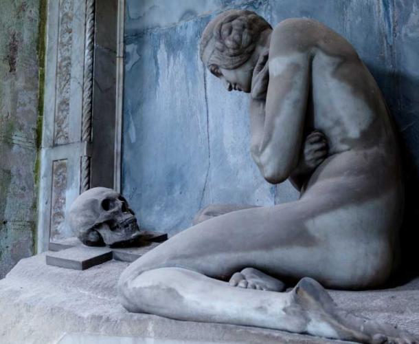 The Grave of Lavarella (1914). A naked woman peers down at the skull of a loved one on top a sarcophagus (Paolo Photography / Adobe Stock)