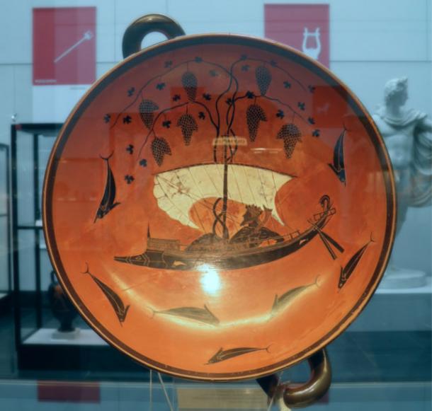 The Greek god of wine, Dionysus, crosses the sea in his dolphin boat with grape vines above the sail in a bowl from 530 B.C. by Exsekias. 