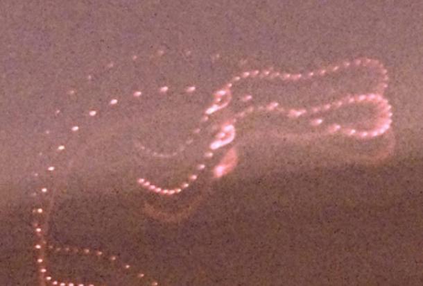 Photograph of an ITE-2 showing its movement. The entity consists of lights of different colors that are pulsating and move synchronously according to a complex trajectory during the 15 seconds of exposure, including a point in which motion stopped for a few seconds, to resume thereafter.