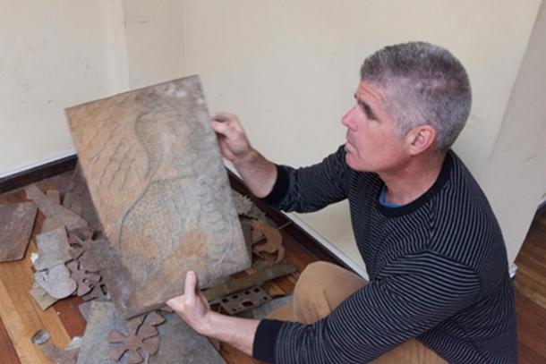 Jim Vieira examining one of the metallic plates that had been tossed in a corner in an old storage room.