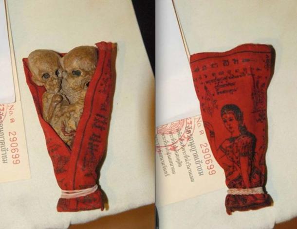 A reproduction Kuman Thong sold as a souvenir at the Buddhist temple at Ayutthaya, Thailand, wrapped in a cloth featuring Nang Kwak.