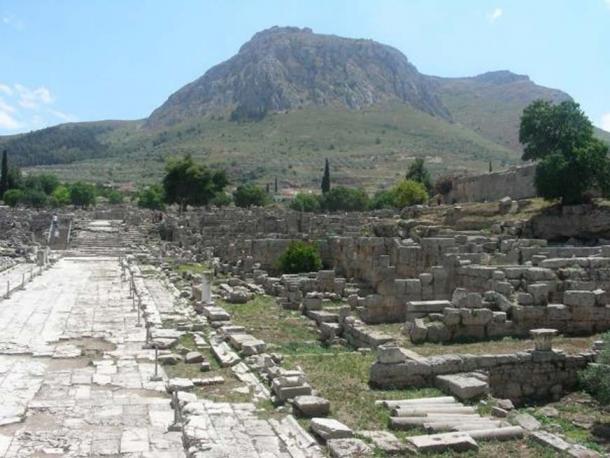 Lechaion Road, entering from the north-west (top) and facing south-east, with Acrocorinth in the background (bottom).