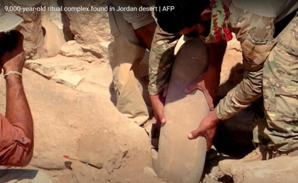 Levantando uno de los dos menhires neolíticos que habían sido inscritos con figuras antropomórficas en el desierto oriental de Jordania. (Captura de pantalla de YouTube/AFP)