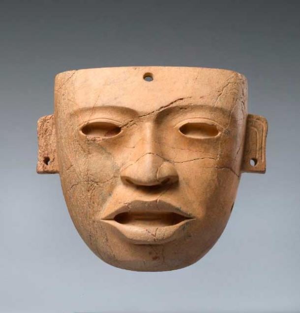 Máscara funeraria de piedra precolombina, 250 - 450 dC, Teotihuacan, México (Fundación Vilcek). Se dice que la máscara se colocó sobre la cara de un individuo de élite fallecido y se ató con una cuerda a través de los agujeros en las orejas.