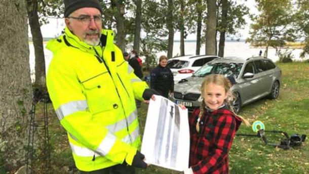 Mikael Nordström and sword finder Saga Vanecek with a photo of the sword near Vidöstern lake. (Image: SVT)