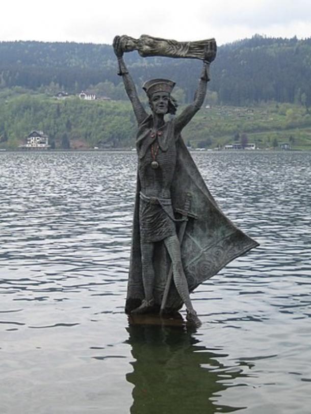 Modern statue of Domitian, casting a pagan idol into Lake Millstatt