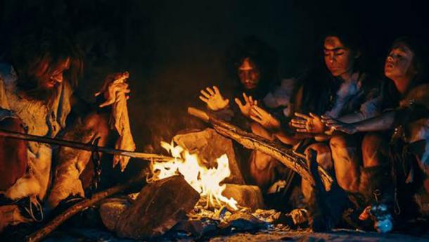 Neandertales cocinando carne de animales alrededor de un fuego, que probablemente fue el escenario de la Casa Althorp hace 40.000 años. (Gorodenkoff / Adobe Stock)