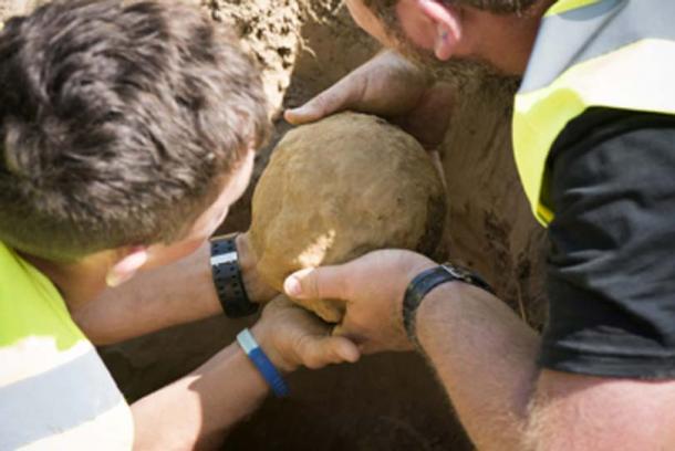 Oliver Horncastle and Alastair Eager removing the howitzer shell from the Battle of Waterloo. (Chris van Houts / Waterloo Uncovered)