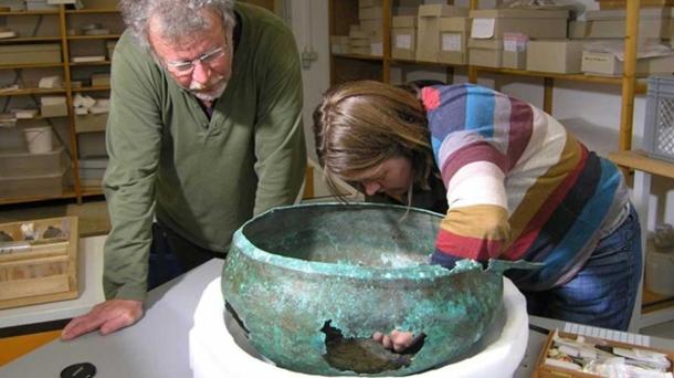 Paleobotanist Manfred Rösch and conservator Tanja Kreß sample the ancient cauldron in Tübingen, Germany.