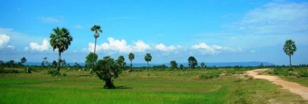 Phnom Kulen mountain range appears as a long, continuous silhouette in the background. 