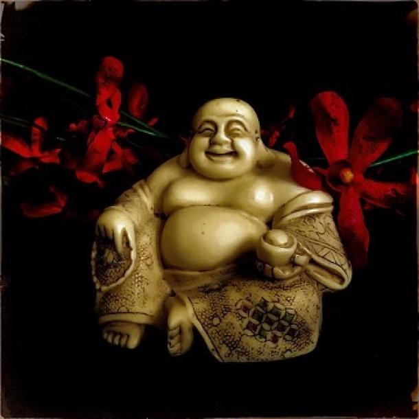 Photo of a Budai figurine and cloth flowers
