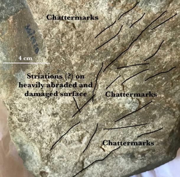 Potential signs of glacial erosion on the rugged and weathered surface of the boulder 