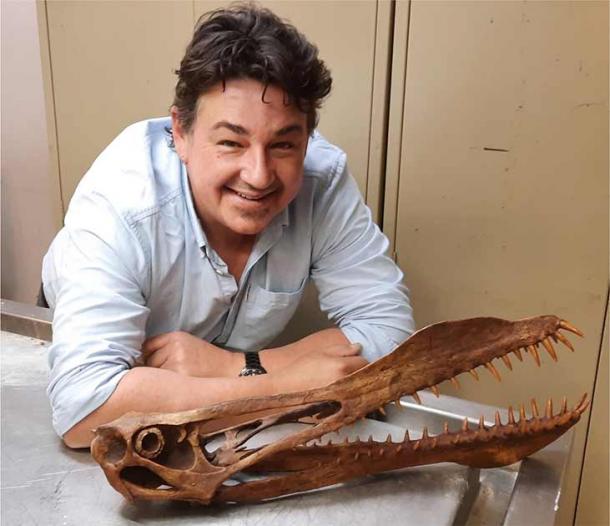 Tim Richards, candidato a doctorado en la Universidad de Queensland, posa con un modelo del pterosaurio australiano que fue reconstruido a partir del fósil de la mandíbula de la criatura, encontrado en una cantera al noroeste de Richmond en junio de 2011 por Len Shaw, un buscador de fósiles local. (La Universidad de Queensland)
