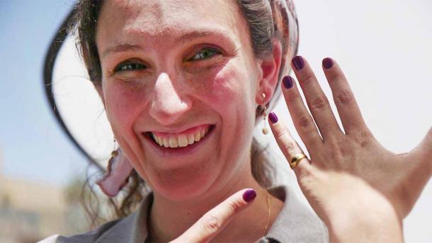 Ring finder, Tahya Gangata, showing off the ring. (Israel Antiquities Authority)