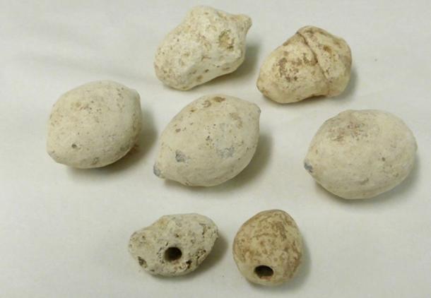 Some of the Roman sling bullets found at the Burnswark Hill battle site in Scotland. The two smallest bullets, shown at the bottom of this image, are drilled with a hole that makes them whistle in flight.
