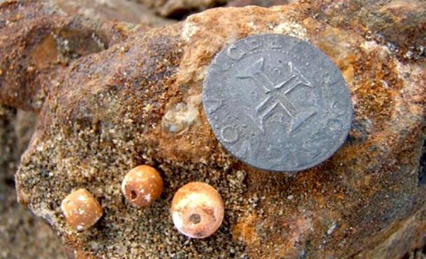 Rosary beads and a silver Portuguese coin that were found with the wreck.