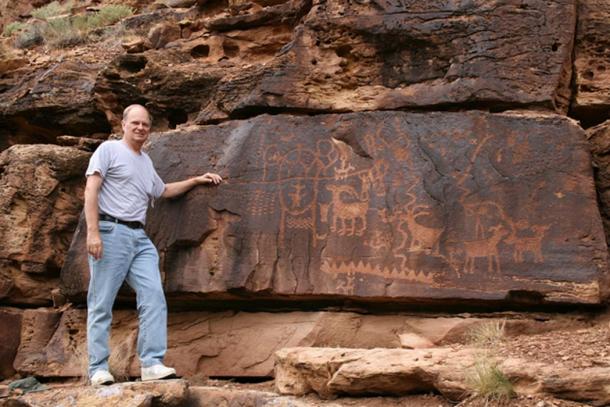 John A. Ruskamp stands near petroglyphs that match ancient Chinese script in Nine Mile Canyon, Utah.