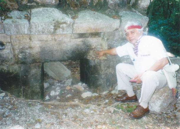 Sayil, Yucatan Mexico. Maya Elder Hunbatz Men points to a symbol for great age on the door frame of a building partially sunk in the ground. This area was deluged by flooding and perhaps tsunamis. (Photo: Cliff Dunning)