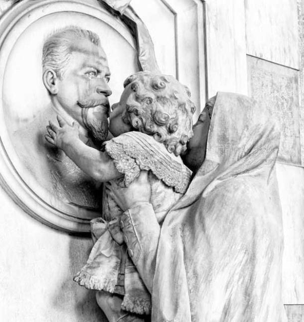 Sculpture of a woman holding up her young child to kiss the face of her deceased father, Staglieno Cemetery (Nazario / Adobe Stock)