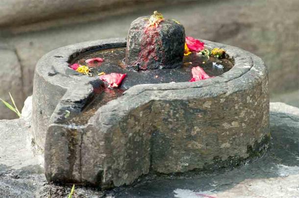 A Shiva lingam is probably the most common symbol of Shaivism. The Shiva representation in this photo is the erect stone column in the middle, surrounded by what is held as the ‘yoni’ or female genitalia. (viktorov.pro / Adobe Stock)