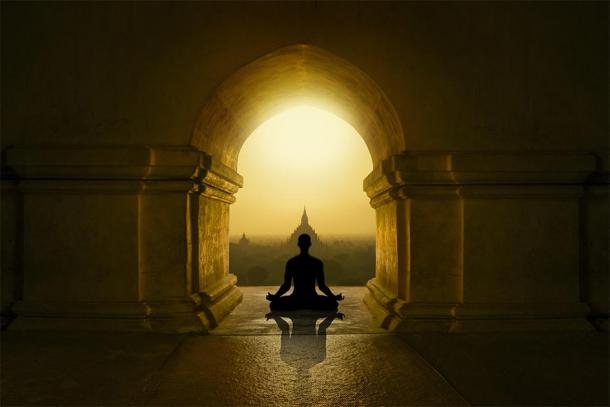 Silhouette meditating in Buddhist temple. (quickshooting / Adobe stock)