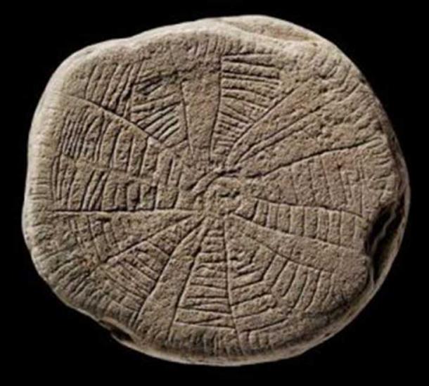 Spiders web design on a stone with smooth worn edges.