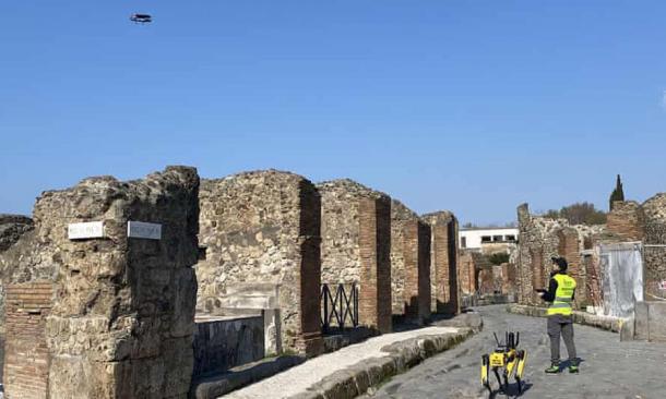 Spot the robotic guard dog following a worker who is guiding a drone at the Pompeii Archaeological Park. (Pompeii Archaeological Park)