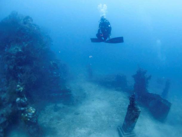 Statues standing on the sea-bed by the split gate to the temple 