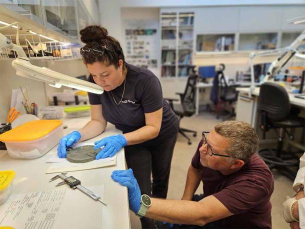 Dr. Guy Stiebel and Liat Oz with the rare mirror that once belonged to a Hellenistic escort. (Yoli Schwartz / Israel Antiquities Authority)