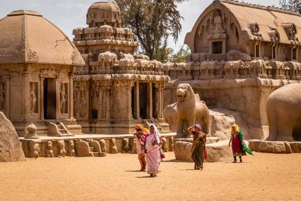Tamil Nadu is an ancient land as this modern image reveals. Hindu women visiting the ancient Hindu monolithic of Pancha Rathas, Mahabalipuram, Tamil Nadu, India. (matiplanas / Adobe Stock)