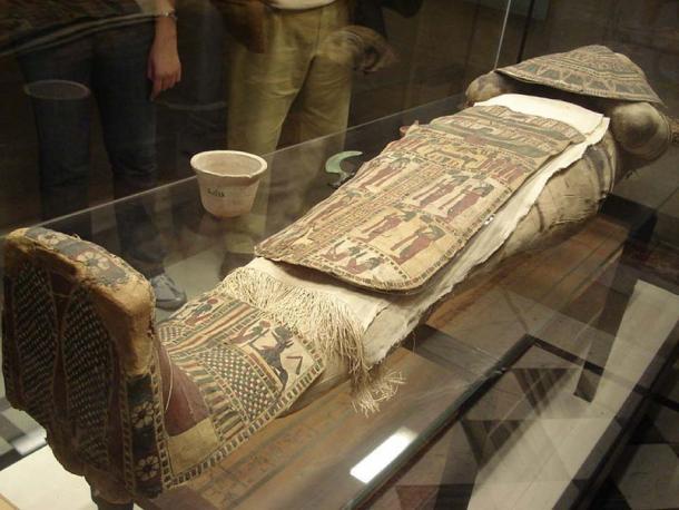 The face mask and apron are decorated with symbolic designs and images. (CC BY-SA 3.0)