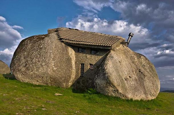 The stone house in Portugal, with visible bars on the windows. 