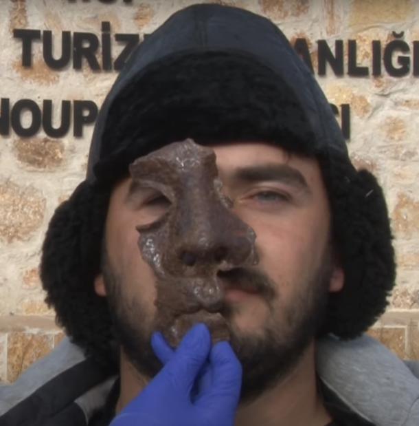 Un hombre turco que llevaba la máscara romana del calvario de hierro hallada recientemente en Hadrianópolis, Turquía. (Captura de pantalla de YouTube / DHA)