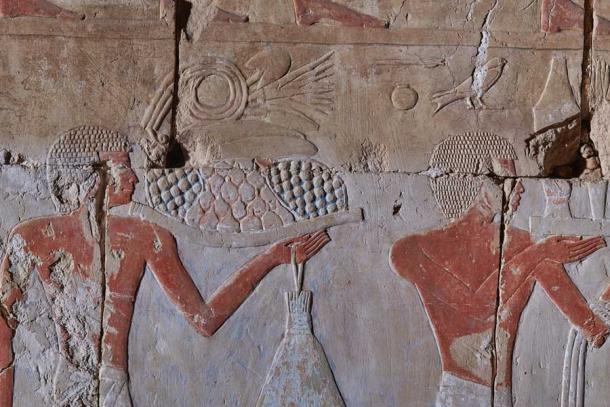 Dos portadores de ofrendas en la capilla de Hatshepsut. La confección de sus pelucas indica que dos escultores trabajan codo con codo, un aprendiz (figura de la izquierda) y un maestro (figura de la derecha). (Maciej Jawornicki / Antiquity Publications Ltd)