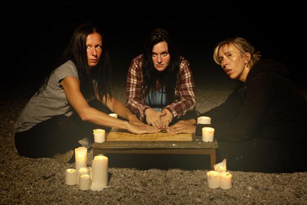 Woman spiritualists communicating with ghosts through spiritual board. (Couperfield / Adobe)