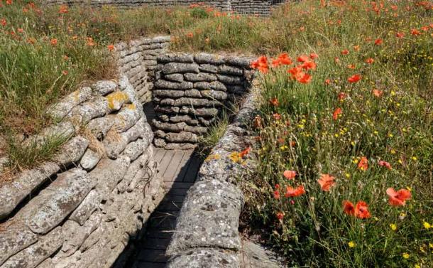 A World War I trench in a field in Flanders flanked by poppies not far from Celtic Wood. Memories of loss and suffering. (Erik_AJV / Adobe Stock)