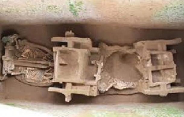 The Zhou Dynasty chariot with horse skeletons at left in the grave