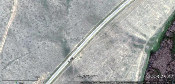 Satellite image showing the road R-259 bisecting an ancient Torgay geoglyph in Kazakhstan.