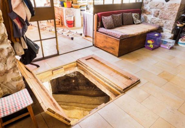 The ancient bath is concealed beneath a pair of wooden doors in the family living room. 