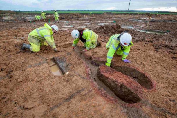 Tres arqueólogos excavando un horno romano en el yacimiento. La cámara de combustión con su base central está a la derecha. (MOLA)