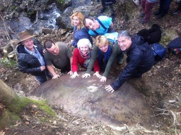 People visiting the giant stone sphere in Bosnia.