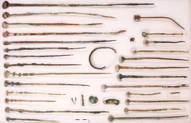 Estas pinzas de bronce para ropa, espirales de metal, un diente de animal colgando envuelto en metal fueron recuperados del pozo. (Marcus Guckenbiehl/ Oficina Estatal de Conservación de Monumentos de Baviera)