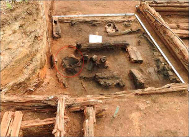 A big clay pot ('korchaga'), circled in red, was standing next to the stove.