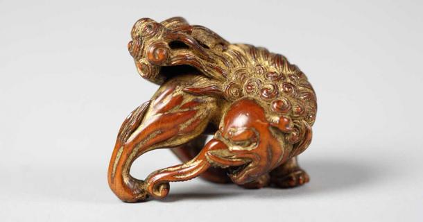 18th century carved wooden netsuke, a type of miniature sculpture originally used to attach items to the sash of a man's traditional clothing. This netsuke depicts a crouching Baku and was created by the Edo period Japanese artist Sadatake. (Public domain)